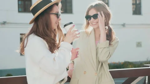 Two young beautiful smiling hipster girls in trendy white sweater and coat Stock Footage 142522341