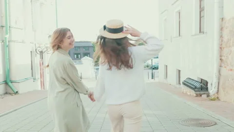 Two young beautiful smiling hipster girls in trendy white sweater and coat Stock Footage 142524641