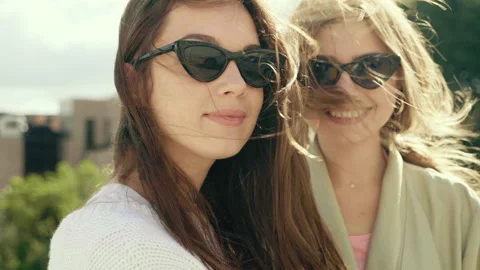 Two young beautiful smiling hipster girls in trendy white sweater and coat Stock Footage 142531143