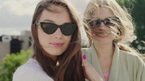 Two young beautiful smiling hipster girls in trendy white sweater and coat Stock Footage 142556034