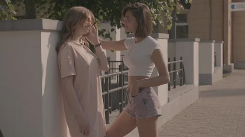 Two young beautiful smiling hipster girls in trendy summer clothes Stock Footage 146032059