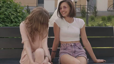 Two young beautiful smiling hipster girls in trendy summer clothes Stock Footage 146032170