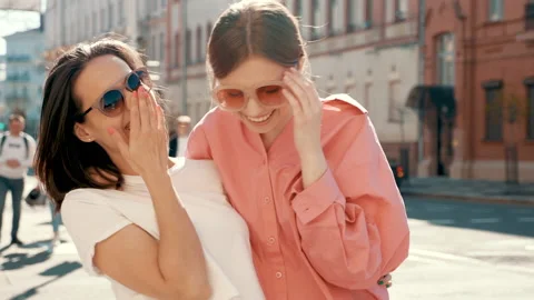 Two young beautiful smiling hipster female in trendy summer posing outdoors Stock Footage 154906430