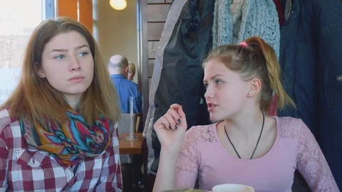 Two young blondes talking at table in cafe Stock Footage 89027642