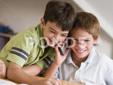 Two Young Boys Calling Someone On A Cellphone Stock Photos