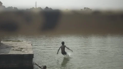 Two young boys diving in a lake 스톡 동영상 87496202