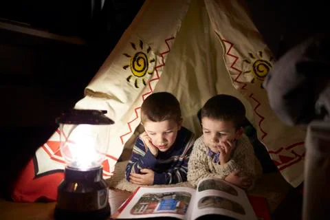 Two Young Boys Reading Inside Tent Set Up Indoors Stock Photos