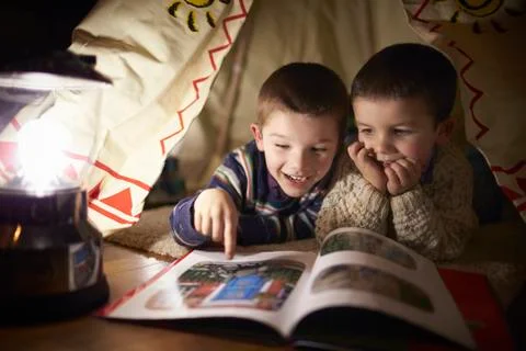 Two Young Boys Reading Inside Tent Set Up Indoors Stock Photos