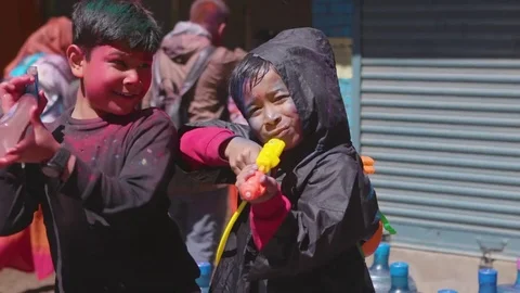 Two young boys with spray bottles enjoying the Holi festival Stock Footage 77448817