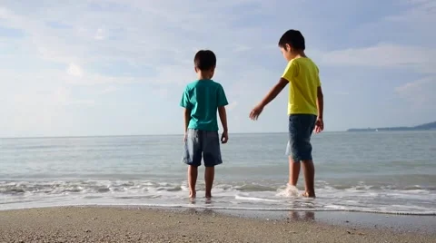 Two young boys standing on the beach Stock Footage 57813220