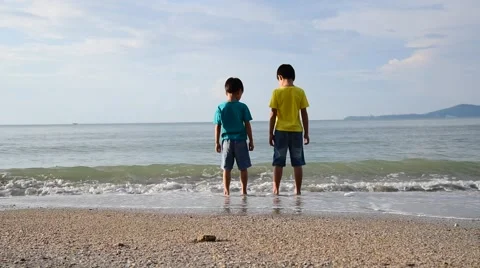 Two young boys standing on the beach and look into the far ocean Stock Footage 58168737