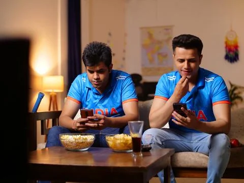 Two young brothers checking the live cricket score - placing online bets, Ind... Stock Photos