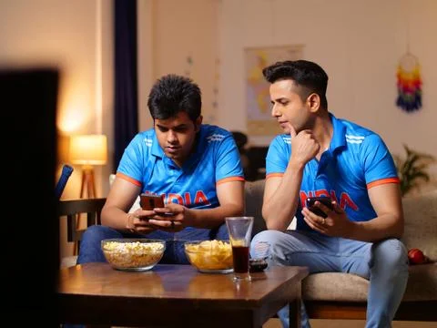 Two young brothers checking the live cricket score - placing online bets, Ind... Stock Photos
