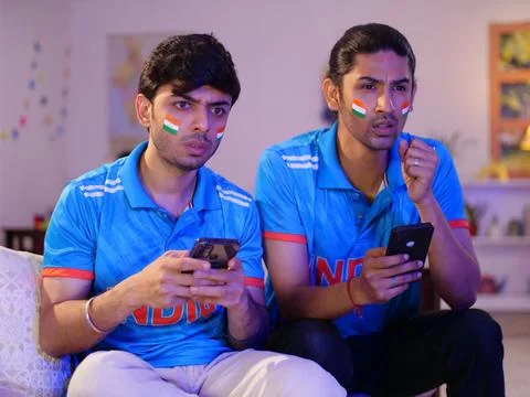 Two young brothers checking the live cricket score - placing online bets, Ind... Stock Photos
