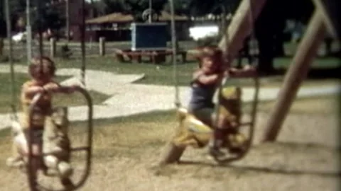 Two young brothers playing slide and swings in park Stock Footage 194511853