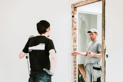 Two young builders are talking to each other. Stock Photos