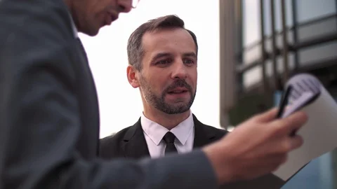 Two young business men standing outdoor and talking. Businessmen in sunglasses Stock Footage 110208404