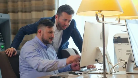 Two young businessman using computer for work in lobby modern office in bank Stock Footage 91376852
