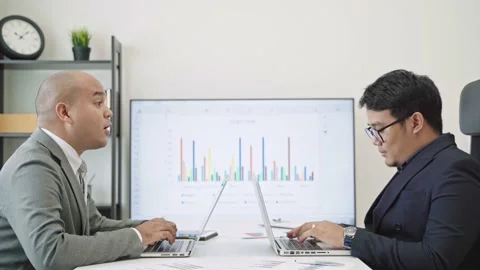 Two young businessmen are working in the office. They uses a laptop for work.4K  Stock Footage 149804836