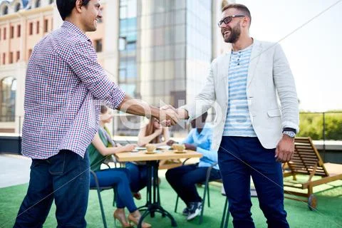 Two young businessmen handshaking outdoors Stock Photos