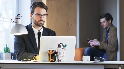 Two Young Businessmen. One of Them is Talking on the Phone Stock Footage 70914528
