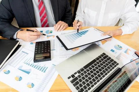 Two young businessmen partner explaining information and pointing at report d Stock Photos