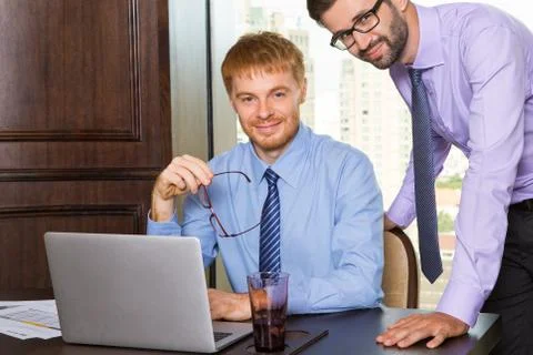 Two young businessmen smiling while posing during working proces Фото