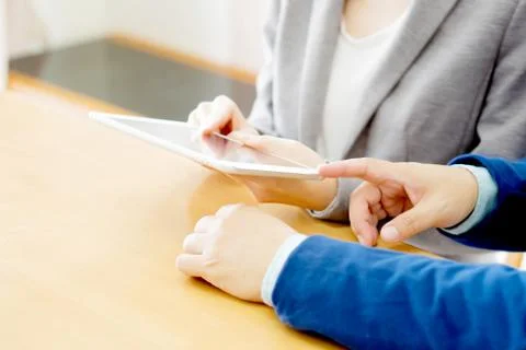 Two young businessmen using touchpad at meeting Stock Photos
