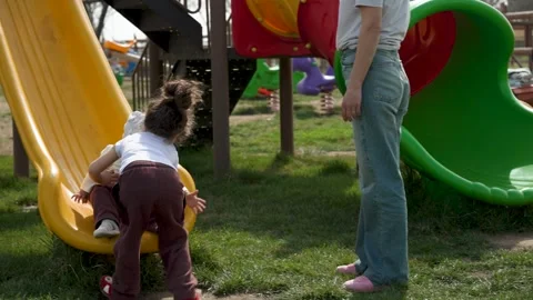 Two Young Children Playing on a Playground Slide Video stock 306732364