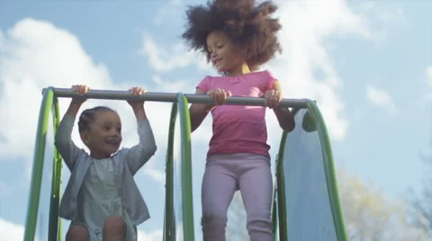 Two young children playing on a slide in slow motion Stock Footage 43240621