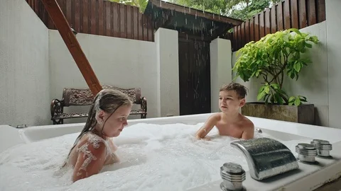 Two young children playing in a spa bath... | Stock Video | Pond5