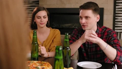 Two young couple relax in a restaurant together, they drink beer eat pizza. Stock Footage 145960761