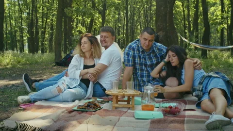 Two young couples man and woman enjoy their vacation in the forest while playing Stock Footage 222088501