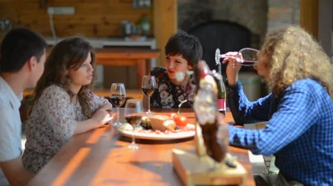 Two young couples sitting, talking, laughing and enjoying some food and drinks Видео 55312916