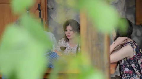 Two young couples sitting, talking, laughing and enjoying some food and drinks Video stock 55313083