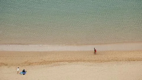 Two young couples spend time on sea coastline. Above view. Stock Photos