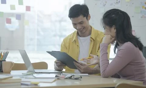 Two young creative designer discussing for their new project together in of.. Stock Photos