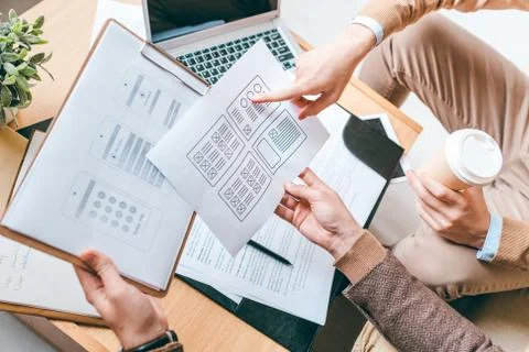 Two young creative designers of software discussing new interfaces of smartphone 스톡 사진