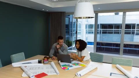Two young creative professionals working together in a modern office Stock Photos