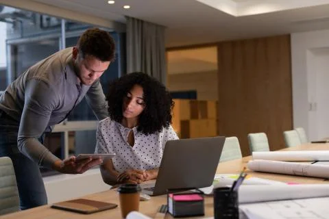 Two young creative professionals working late in a modern office Fotos Stock