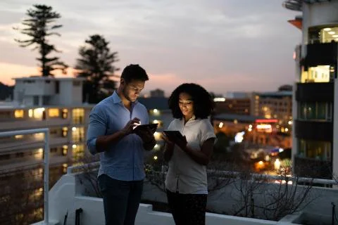 Two young creative professionals working late on office roof terrace Fotos Stock