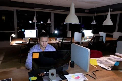 Two young creative professionals working late in a modern office 写真素材