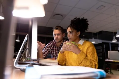 Two young creative professionals working late in a modern office Fotos de archivo