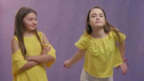 Two young cute beautiful smiling hipster girls in trendy summer clothes. Playful Stock Footage 129340144