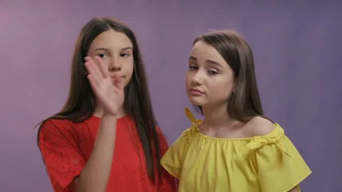 Two young cute beautiful smiling hipster girls in trendy summer clothes. Playful Stock Footage 129359883