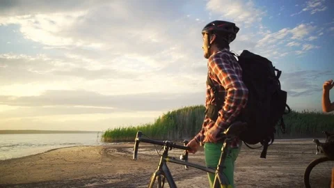 Two young cyclists enjoy the sunset with bikes seaside slow motion rapid Stock Footage 78060258