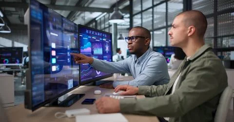 Two Young Data Analysts Reviewing Financial Dashboard On Computer Screen. Stockfoto's