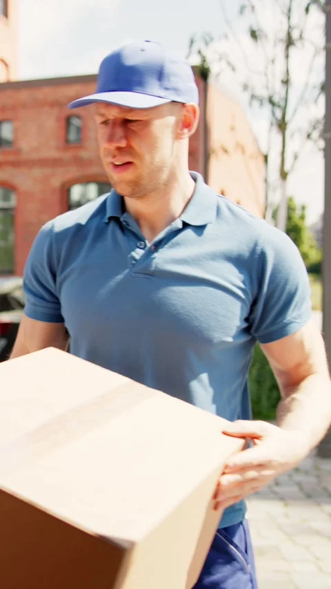 Two young delivery men are loading cardboard boxes into a truck. They are part 스톡 동영상 279801808