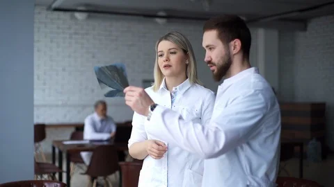 Two young dentists are examining the patient's jaw X-ray. Video stock 125015170