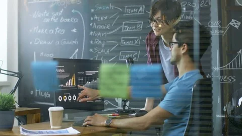 Two Young Developer Work on a Personal Computer, Talking.  Stock Footage 84102154